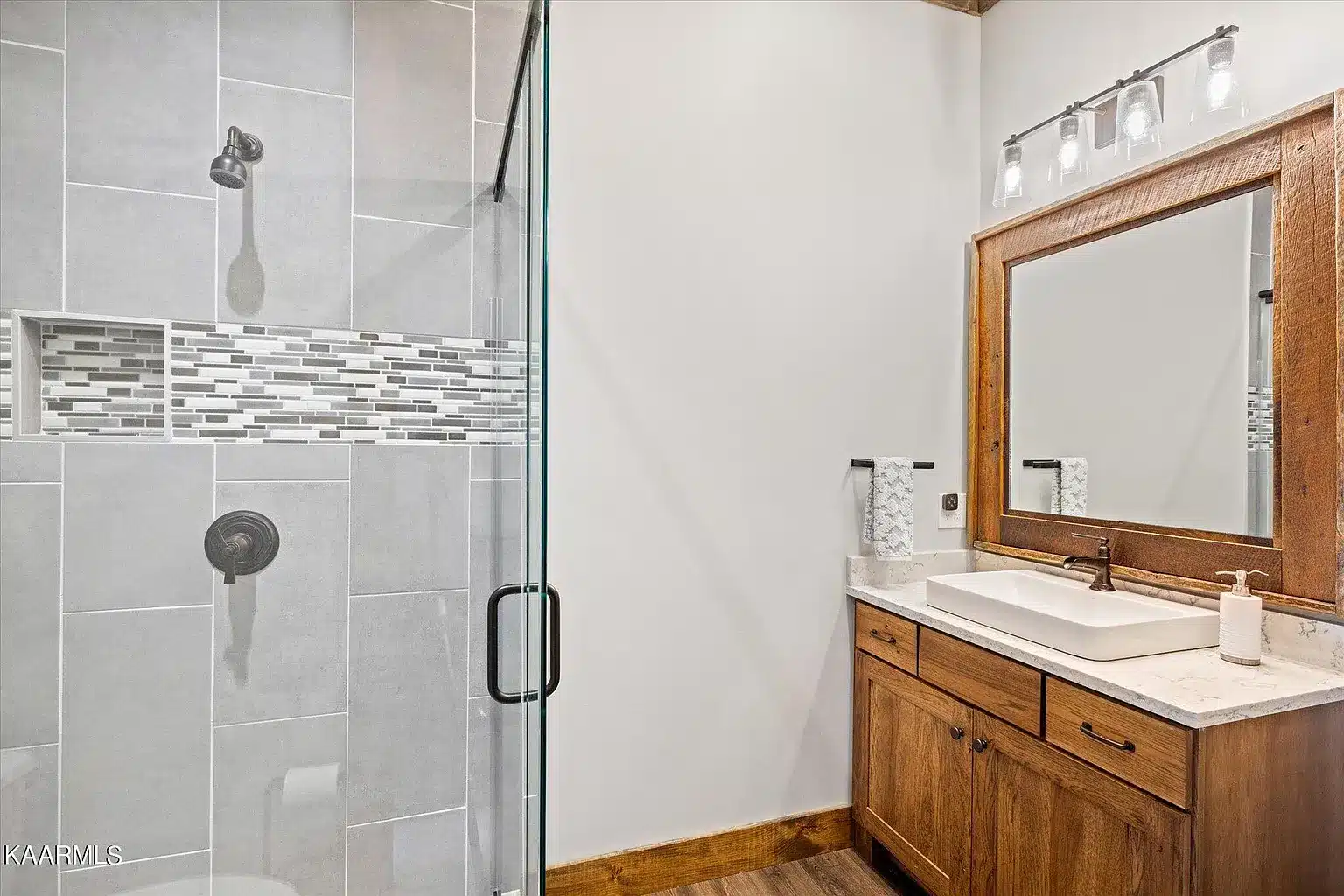 Custom shower with all glass doors, shower seat and space between vanity and glass