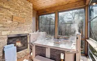 Hot Tub with stone inlay and retractible top in all seasons room with fireplace