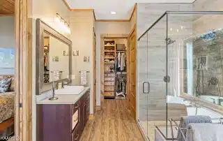 Bathroom with vessel sink and large glass shower with multiple panels